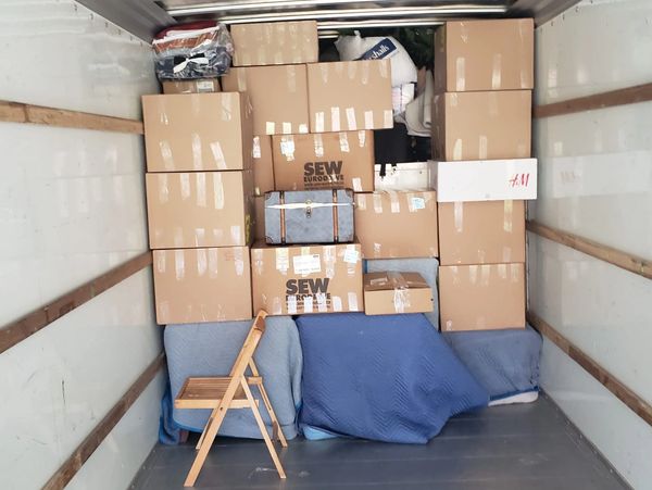 Boxes and furniture packed neatly with care and organized in the moving truck.