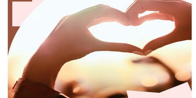 Hands forming a heart shape against a bright, blurred background.