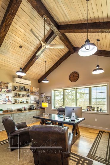 Modern office with wooden ceiling and leather chairs.
