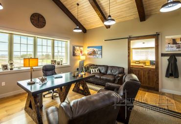 Cozy office with leather furniture and wooden ceiling.