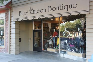 Storefront of Bling Queen Boutique with mannequins and jewelry displays.