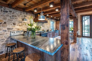 Rustic kitchen with wooden beams and stone walls.