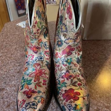 Colorful floral-patterned boots on a countertop.
