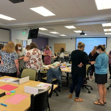 Group of adults engaged in conversation during a workshop or training session.