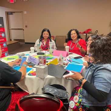 A group of people engaged in a colorful, creative workshop around a round table.