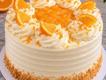 Orange-flavored cream cake with whipped cream and orange slices.