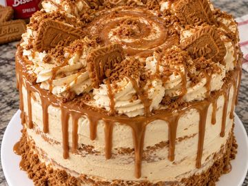 Delicious stacked caramel cake with cream and cookie toppings.