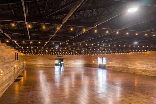 Spacious wooden hall with string lights and polished floor.