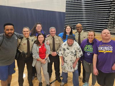 Group photo of diverse people including police officers and civilians indoors.