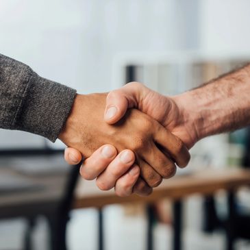 Two people shaking hands in an office.