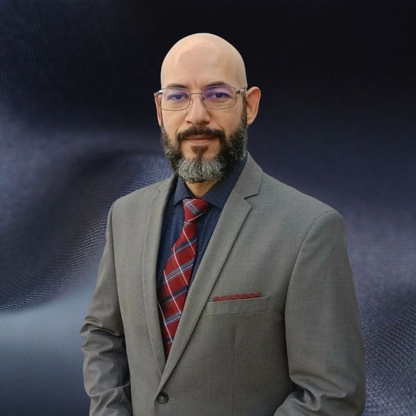 Professional man in a suit with a beard and glasses.