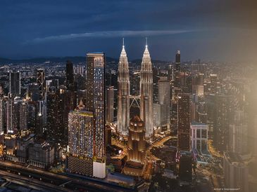 Night view of a city skyline featuring the illuminated Petronas Twin Towers.