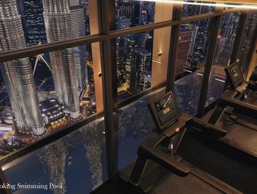 Treadmills overlooking a cityscape with iconic skyscrapers at night.
