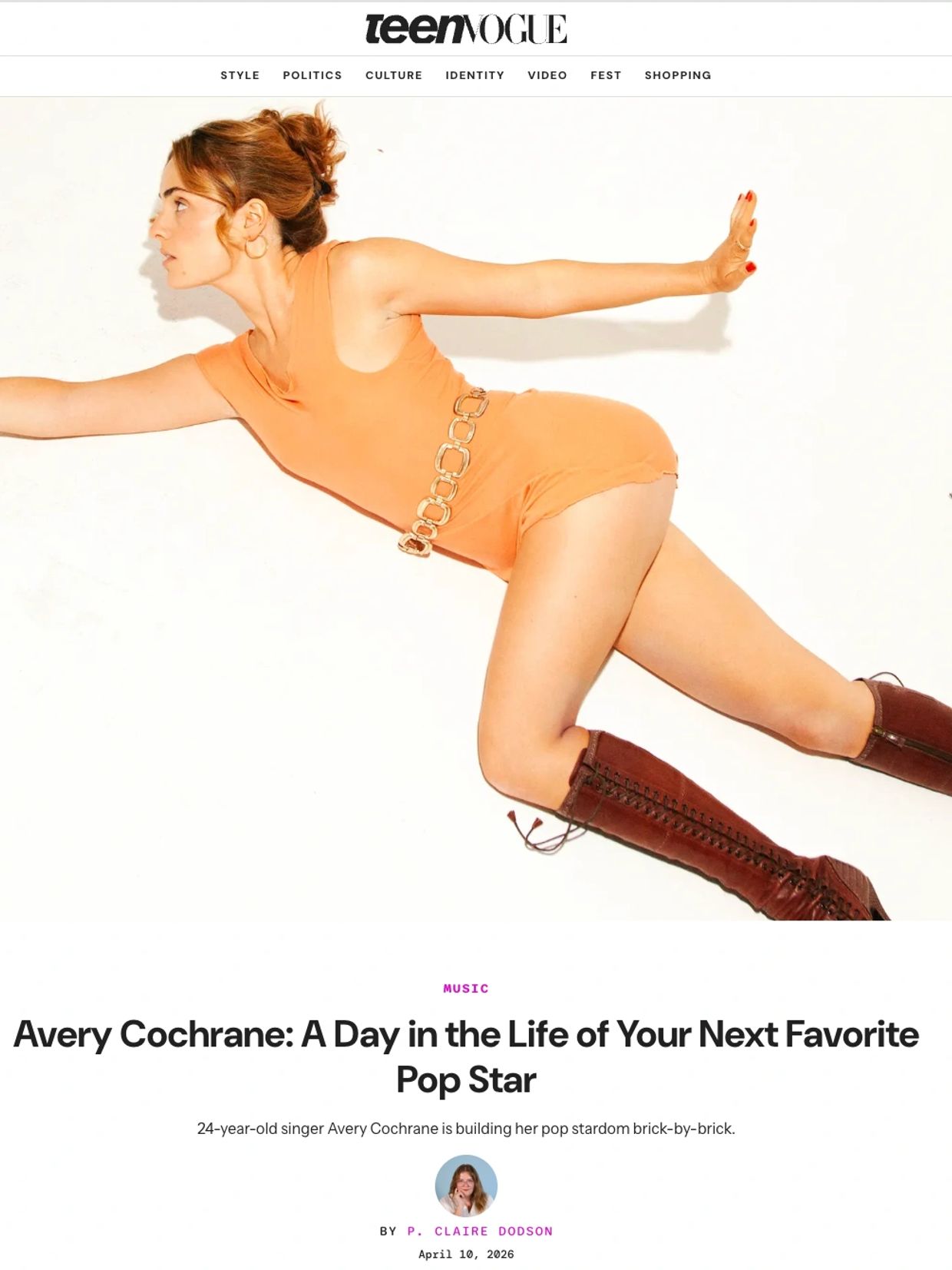 Avery Cochrane poses dynamically in orange with brown boots.