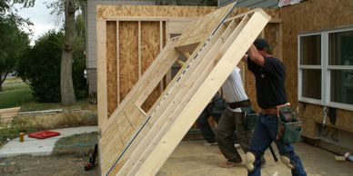 construction workers lifting new wall frame into place new home addition