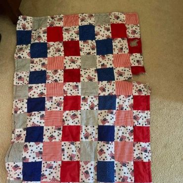 Colorful patchwork quilt with red, blue, and patterned squares.