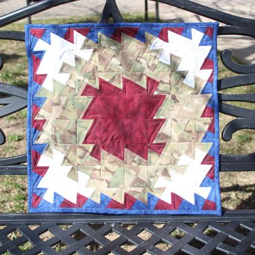 A colorful quilt square with a zigzag pattern.