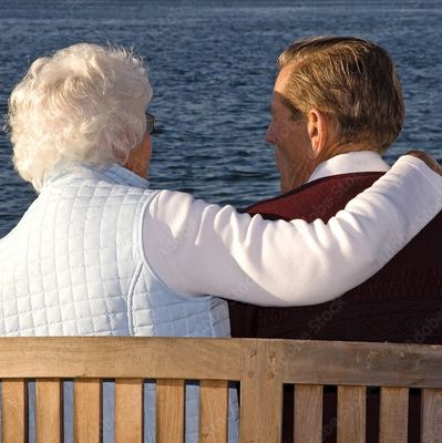 An Elderly Couple Sitting on a Wooden Bench 