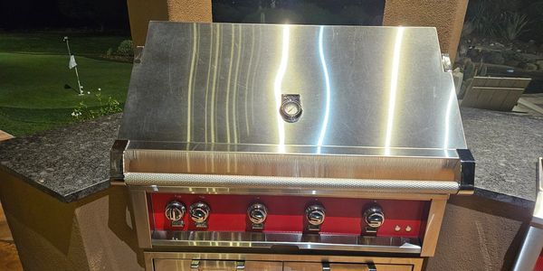 Closed stainless steel outdoor grill at night.
