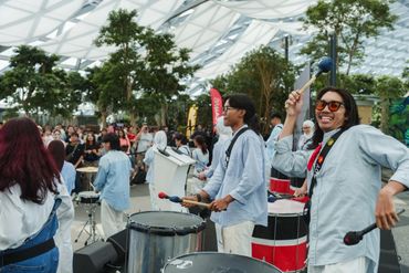 A lively indoor drum performance with an enthusiastic musician.