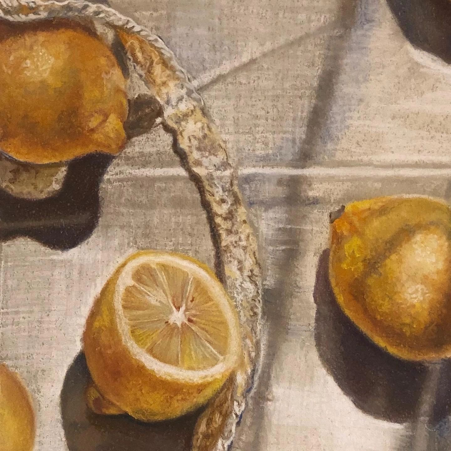 Four lemons on a tablecloth with sun shining on them