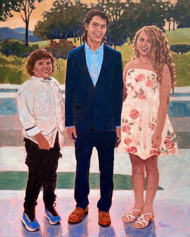 Family portrait of 3 siblings standing outside by a pool with landscape in the background.