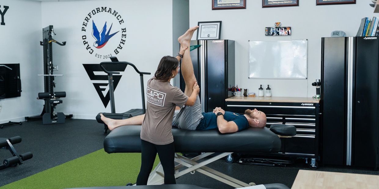 Physiotherapy assistant stretching a patient's hamstrings.
