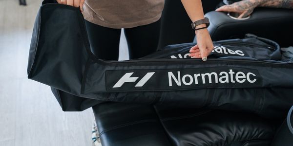 Physiotherapy assistant helping a patient into Normatec compression boots.
