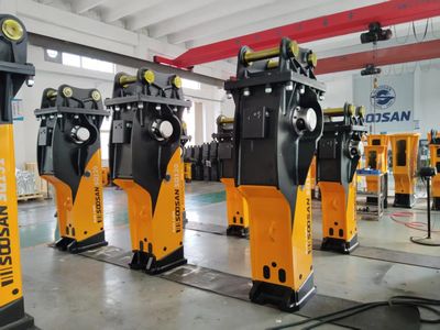 Industrial hydraulic breakers lined up in a factory setting.