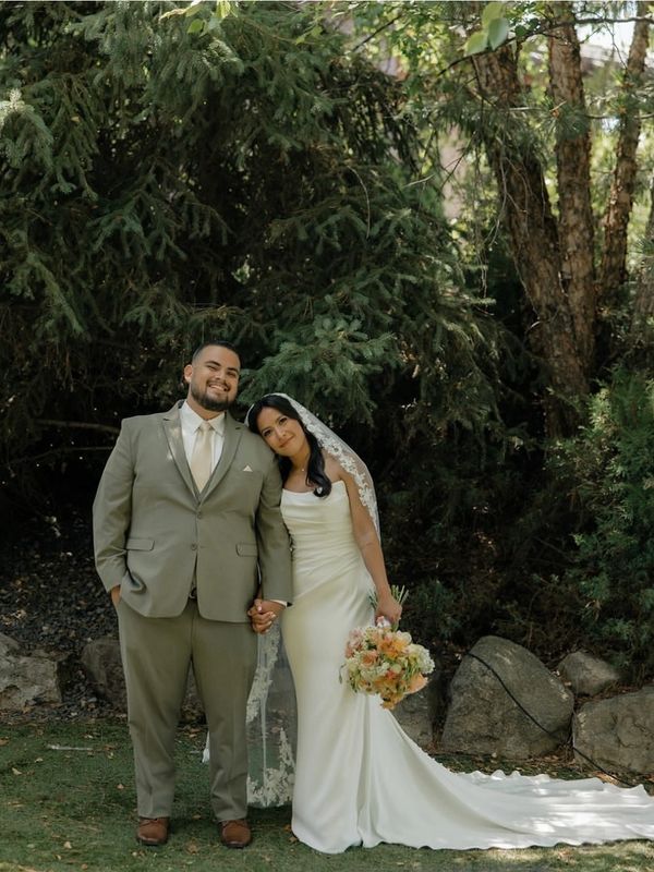 Newlywed couple posing happily outdoors.