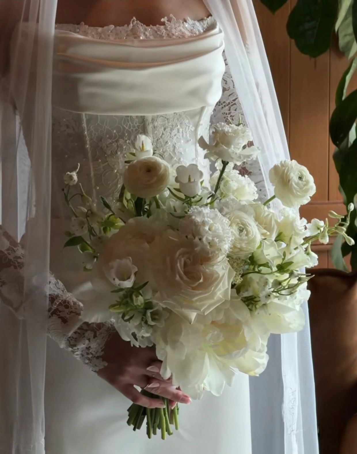 Close-up of a bride holding a white flower bouquet.