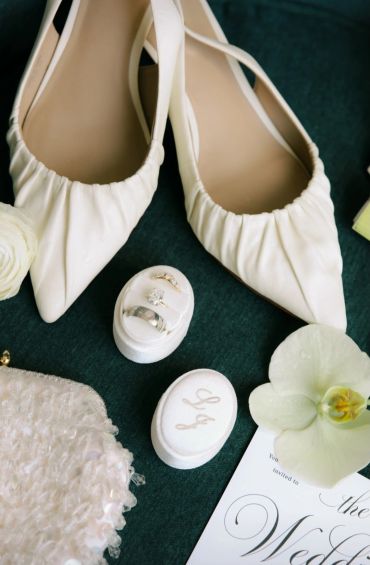 Elegant bridal accessories including white shoes and rings.