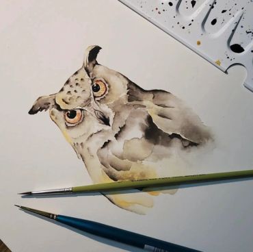 A watercolor painting of an owl in progress.