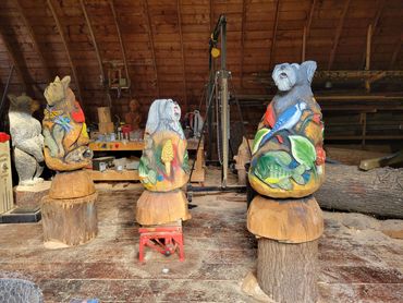 Chainsaw garden Sculptures with Portraits of the clients three dogs and a variety of Flora and Fauna