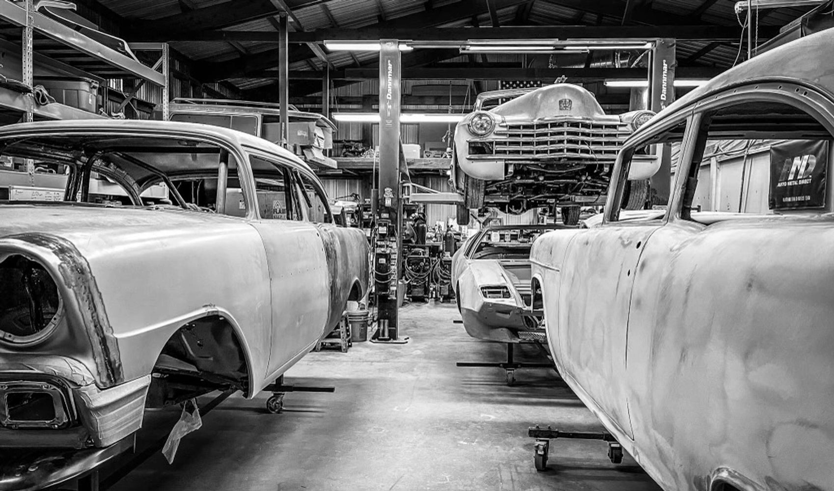 Classic cars in a restoration at a workshop.