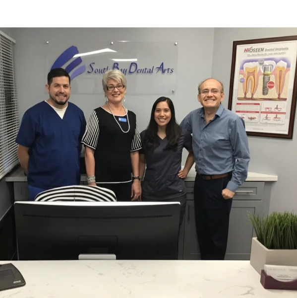 Four dental professionals posing together at South Bay Dental Arts.