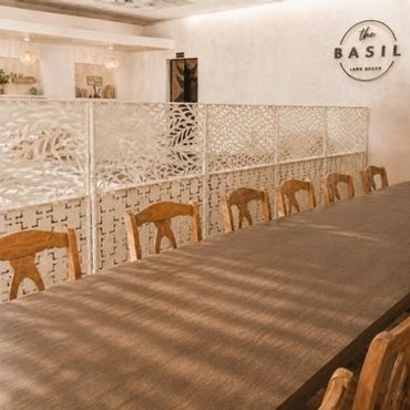 Elegant dining area with wooden chairs and decorative divider in a warm-toned room.