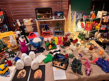A colorful display of various 3D printed figurines and models on a table.