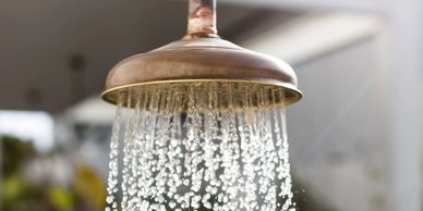 Close-up of water flowing from a showerhead in a bathroom.