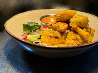 Grilled chicken pieces with dipping sauce and vegetables.