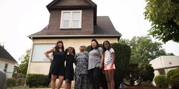 3 generations of the Gordly Burch Family stand outside of the  Gordly Burch home on N. Williams Ave.