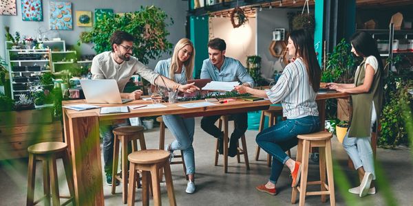 Team collaborating at a wooden table in a bright office.