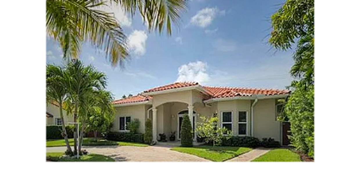 Single-story house with red-tiled roof and palm trees in front yard.