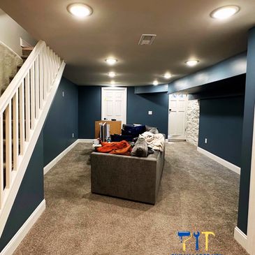 Renovated basement with blue walls and cozy carpet flooring.