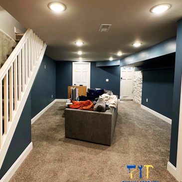 Renovated basement with blue walls and cozy carpet flooring.