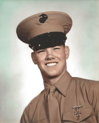 Young man in a Marine Corps uniform smiling at the camera.