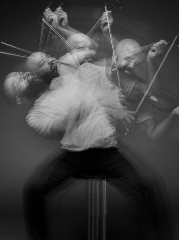 Blurred multiple exposure of a violinist passionately playing.