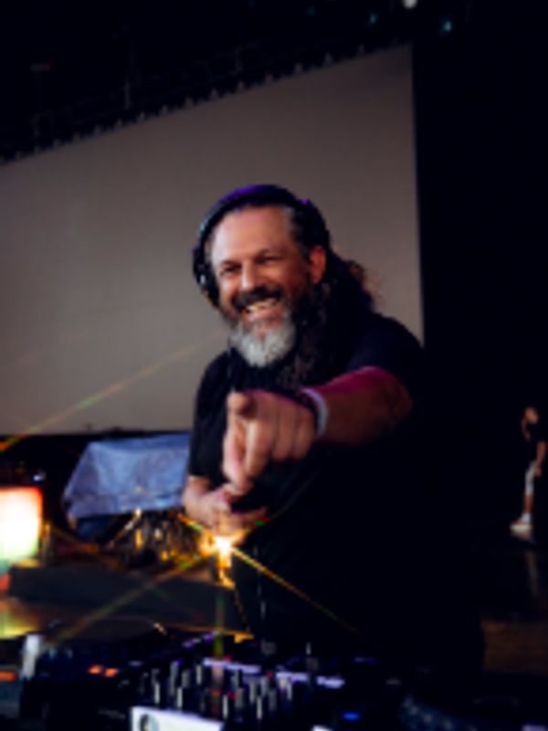 Smiling DJ pointing at the camera during a live performance.