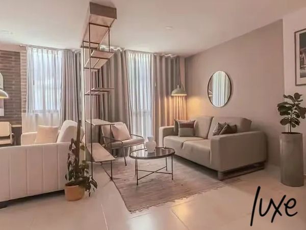 Modern living room with neutral tones, cozy furniture, and stylish decor.