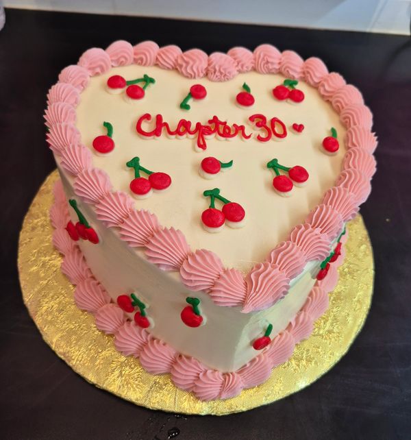 Heart-shaped cake with pink frosting and cherry decorations, celebrating Chapter 30.